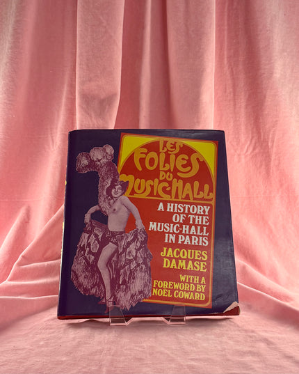 Book titled 'Les Folies du Music Hall' on a pink fabric background