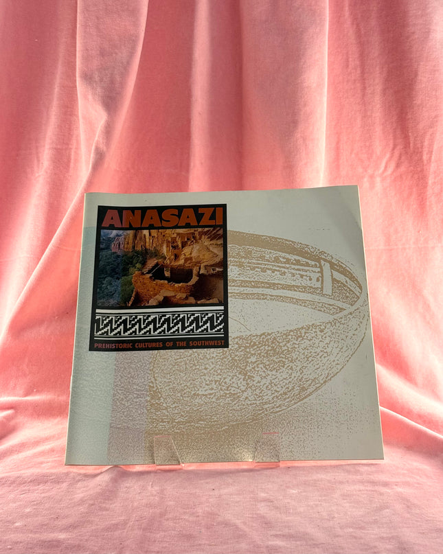Book titled 'Anasazi' on a pink fabric background
