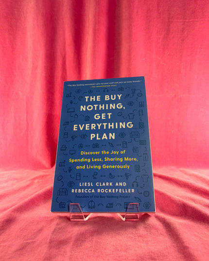 Book titled 'The Buy Nothing, Get Everything Plan' by Liesl Clark and Rebecca Rockefeller on a pink fabric background