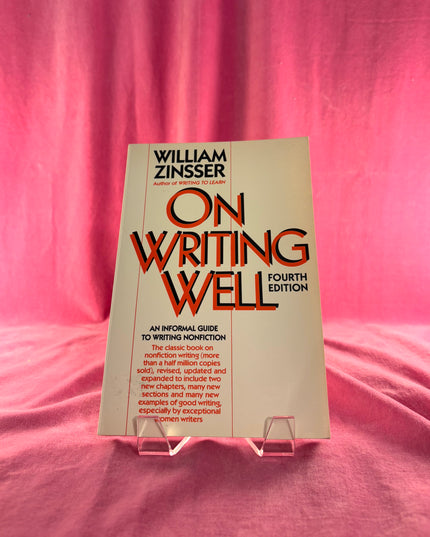 Book titled 'On Writing Well' by William Zinsser on a pink fabric background