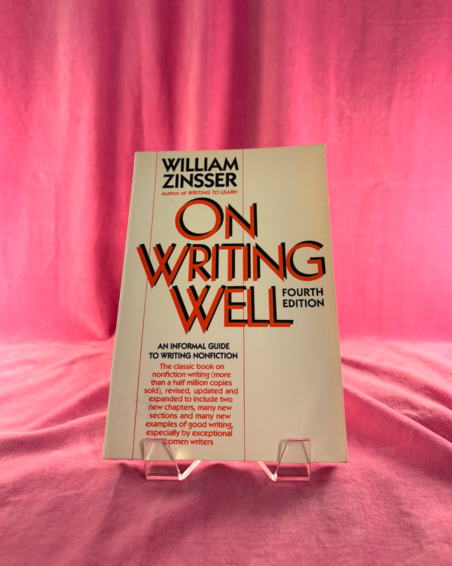 Book titled 'On Writing Well' by William Zinsser on a pink fabric background
