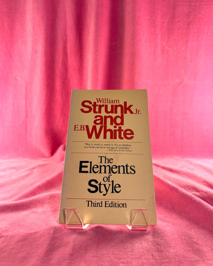 Book titled 'The Elements of Style' by William Strunk Jr. and E.B. White on a pink background