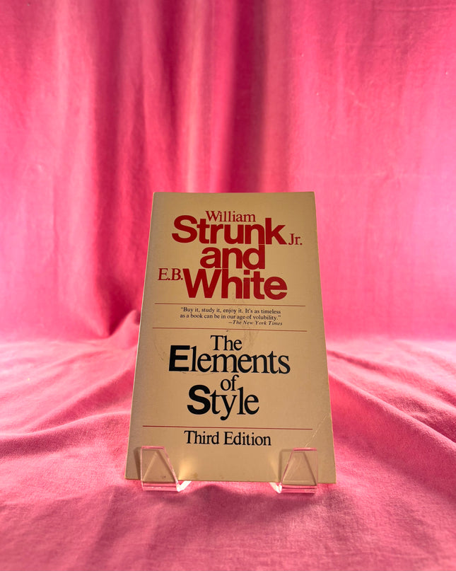 Book titled 'The Elements of Style' by William Strunk Jr. and E.B. White on a pink background