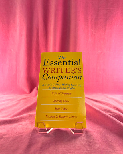 Yellow book titled 'The Essential Writer's Companion' on a pink fabric background