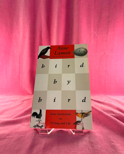 Book titled 'Bird by Bird' by Anne Lamott on a pink background