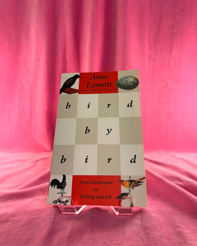 Book titled 'Bird by Bird' by Anne Lamott on a pink background