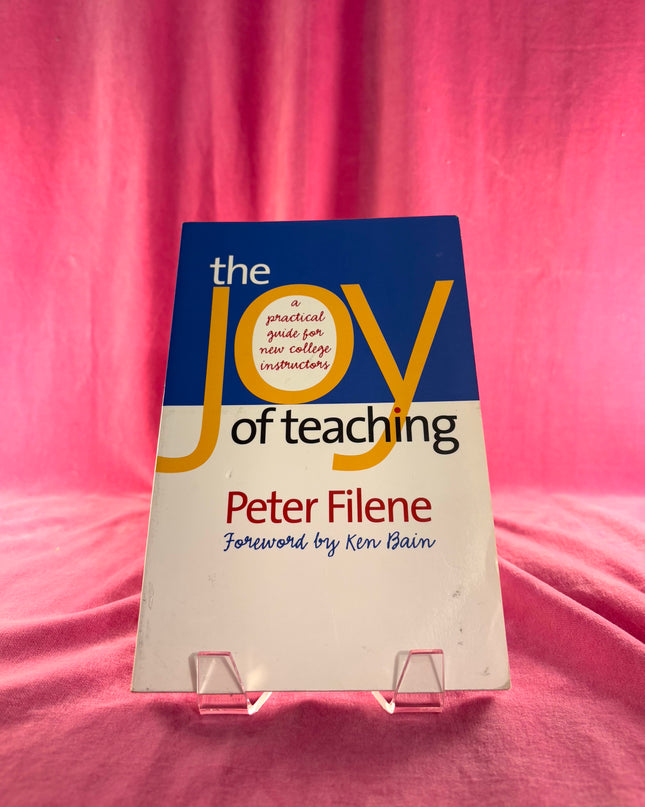 Book titled 'The Joy of Teaching' by Peter Filene on a pink fabric background