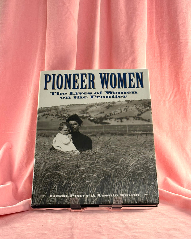 Book titled 'Pioneer Women: The Lives of Women on the Frontier' on a pink fabric background