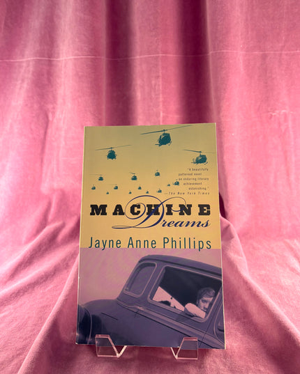 Book titled 'Machine Dreams' by Jayne Anne Phillips on a pink background