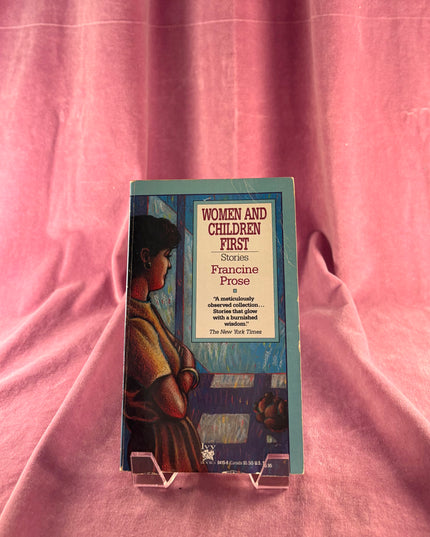Book titled 'Women and Children First' by Panshe Fros on a pink fabric background