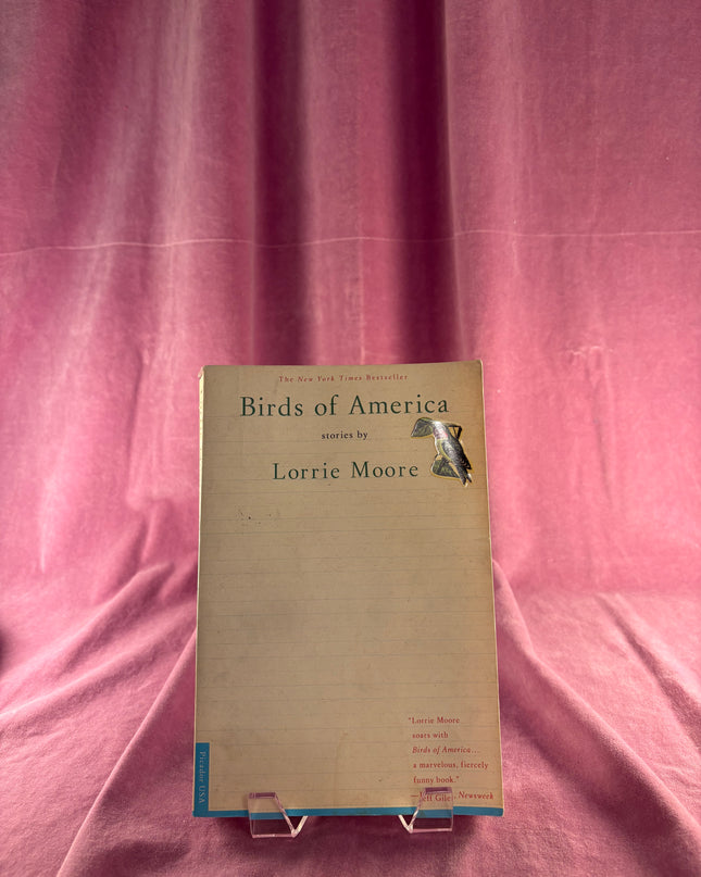 Book titled 'Birds of America' by Lorrain Moore on a pink fabric background