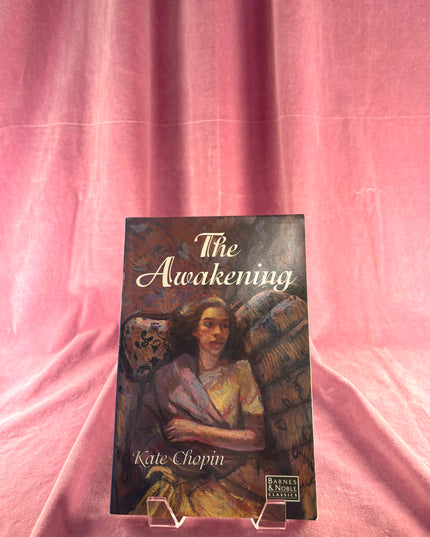 Book titled 'The Awakening' by Kate Chopin on a pink fabric background