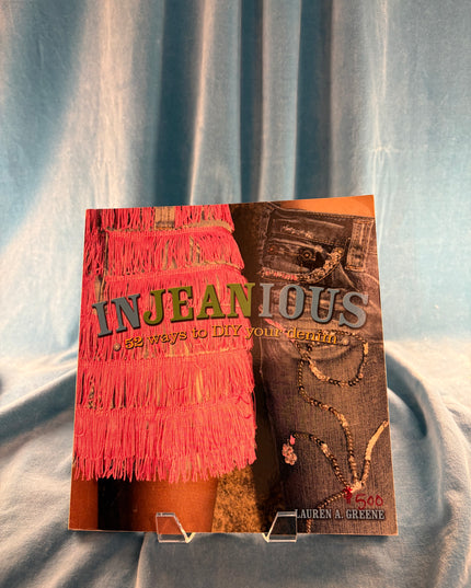 Book titled 'Injeanious' on a textured surface