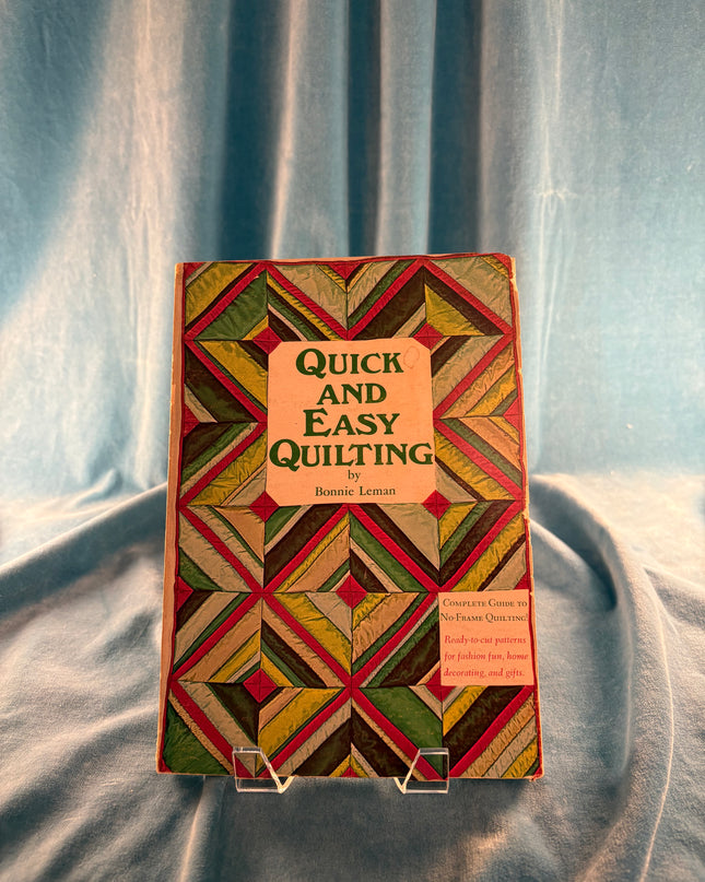 Book titled 'Quick and Easy Quilting' with geometric pattern on cover against a textured background