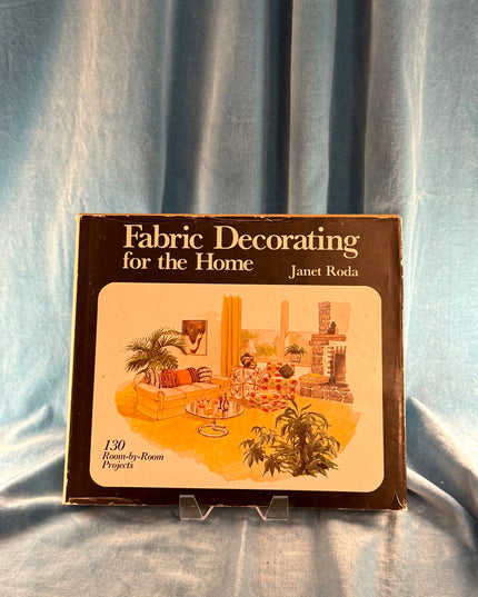 Book titled 'Fabric Decorating for the Home' by Janet Roda on a blue fabric background