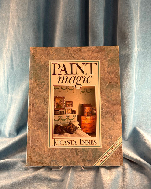 Book titled 'Paint Magic' by Jocasta Innes on a textured fabric background