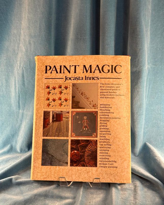 Book titled 'Paint Magic' by Jocasta Innes on a textured blue fabric background