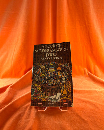 Book titled 'A Book of Middle Eastern Food' by Claudia Roden on an orange fabric background