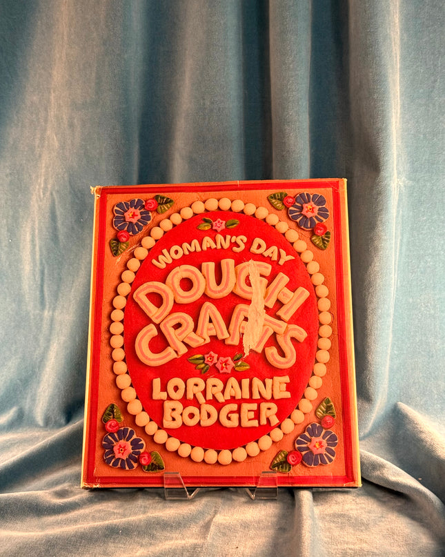 Book titled 'Dough Crafts' by Lorraine Bodger on a textured fabric background