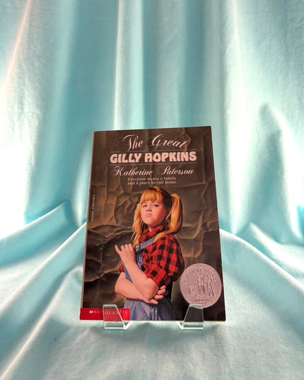 Book titled 'The Great Gilly Hopkins' by Katherine Paterson on a light blue fabric background