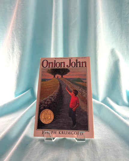 Book titled 'Onion John' by Joseph Krumgold on a light blue fabric background