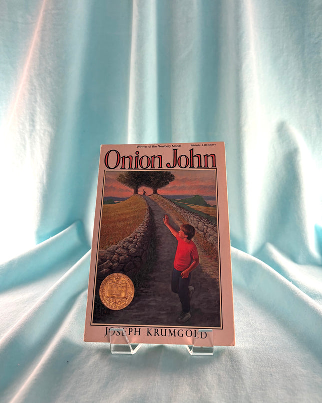 Book titled 'Onion John' by Joseph Krumgold on a light blue fabric background