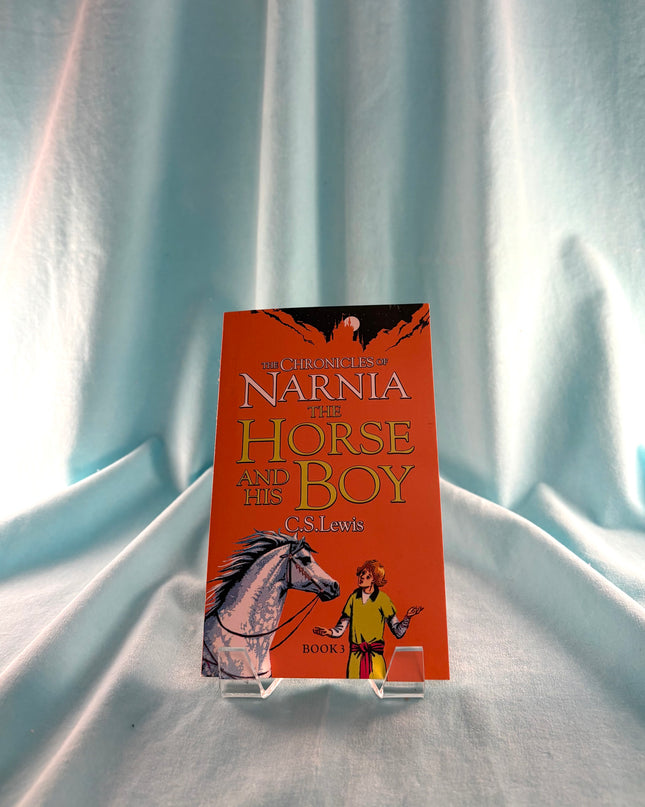Book stand with 'The Horse and His Boy' book by C.S. Lewis on a white fabric background