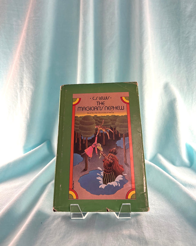 Vintage book titled 'The Magician's Nephew' by C.S. Lewis on a light blue fabric background