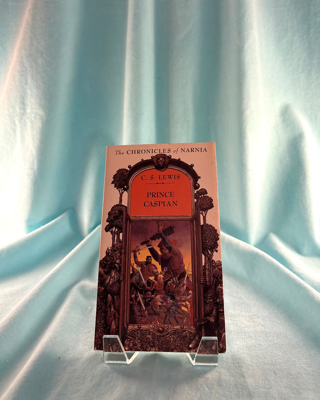 Book titled 'Prince Caspian' by C.S. Lewis on a stand against a light blue curtain background
