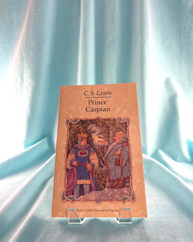 Book titled 'Prince Caspian' by C.S. Lewis on a stand with a light blue curtain background