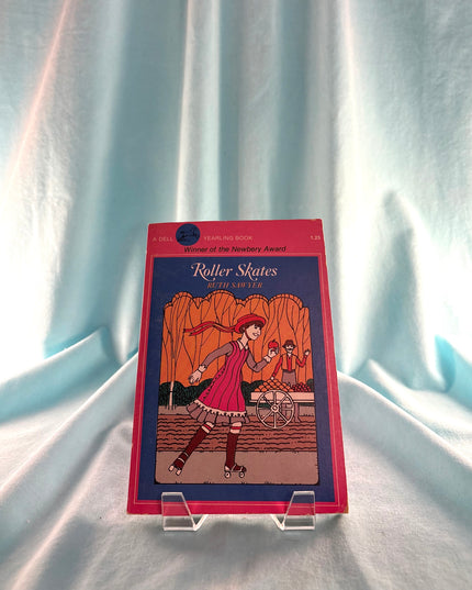 Book titled 'Roller Skates' on a stand against a light blue curtain background