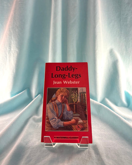 Book titled 'Daddy-Long-Legs' by Jean Webster on a stand with a light blue curtain background