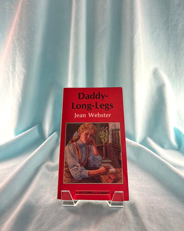 Book titled 'Daddy-Long-Legs' by Jean Webster on a stand with a light blue curtain background