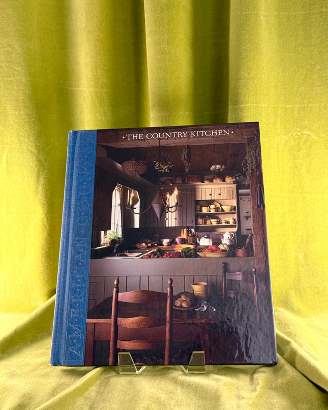 Book titled 'The Country Kitchen' on a yellow fabric background
