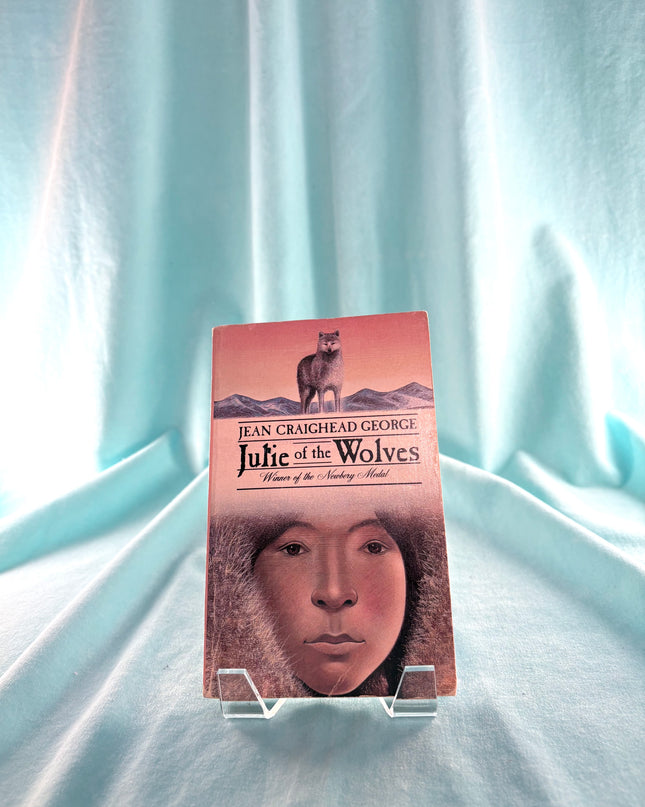 Book titled 'Julie of the Wolves' by Jean Craighead George on a light blue fabric background