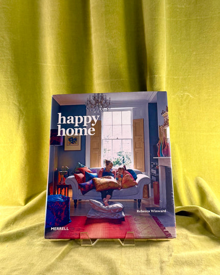 Book titled 'happy home' by Rebecca Winward on a yellow fabric background
