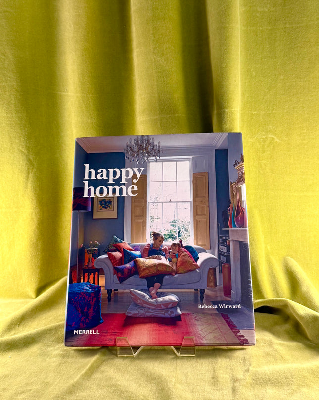 Book titled 'happy home' by Rebecca Winward on a yellow fabric background