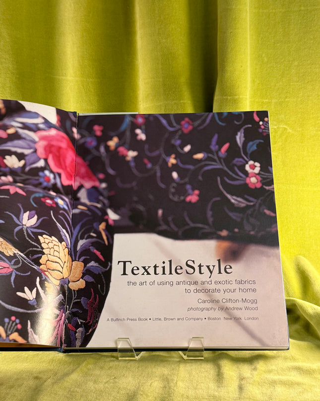 Book titled 'TextileStyle' on a green fabric background