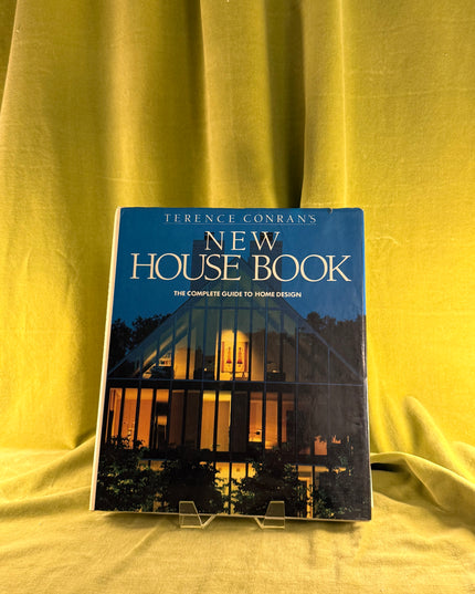 Book titled 'New House Book' by Terence Conran on a yellow fabric background