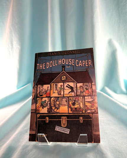 Book titled 'The Doll House Caper' by Jean McConnel on a light blue curtain background