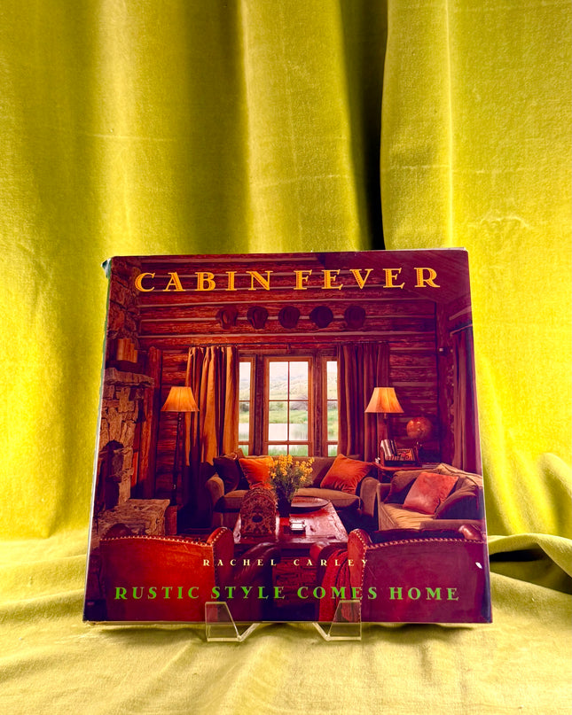 Book titled 'Cabin Fever' by Rachel Carly on a yellow fabric background
