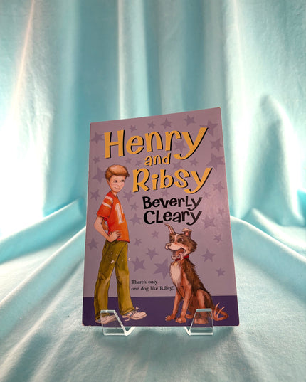 Book cover of 'Henry and Ribsy' by Beverly Cleary on a light blue curtain background