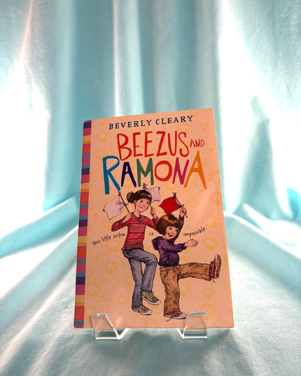 Book titled 'Beezus and Ramona' by Beverly Cleary on a stand against a light curtain background