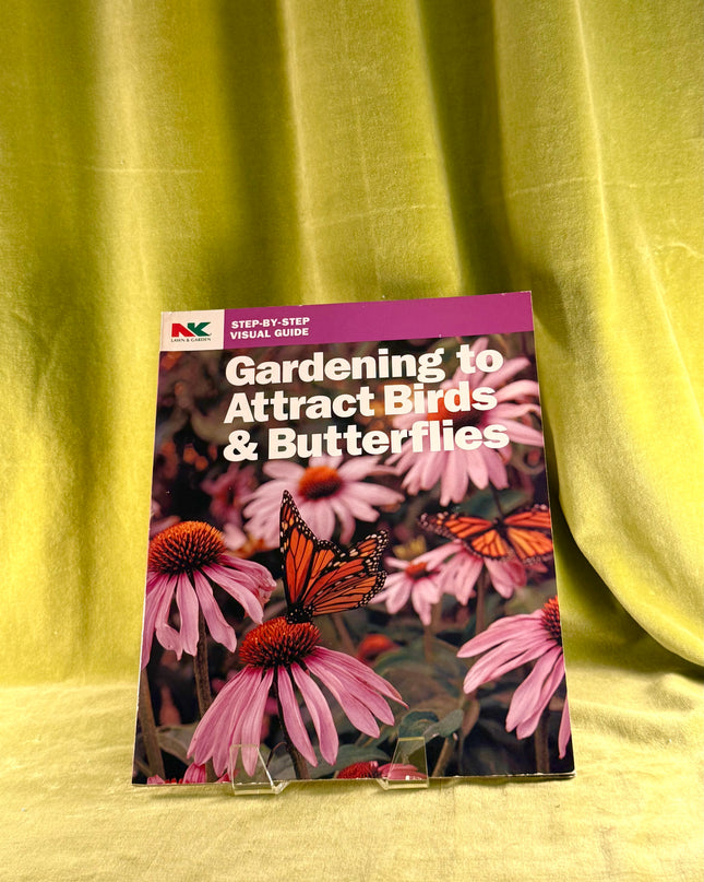 Book titled 'Gardening to Attract Birds & Butterflies' on a yellow fabric background
