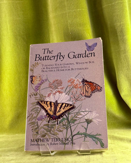 Book titled 'The Butterfly Garden' by Mathew Tekulsky on a green fabric background