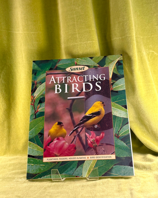 Booklet titled 'Attracting Birds' by Sunset on a green fabric background