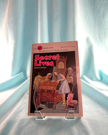 Vintage book titled 'Secret Lives' on a light blue curtain background