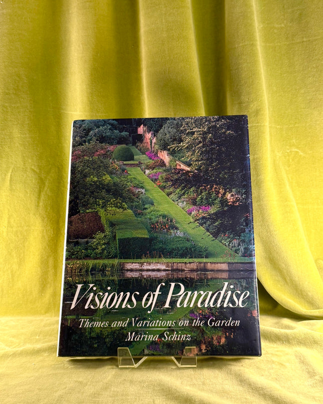 Book titled 'Visions of Paradise' on a yellow fabric background