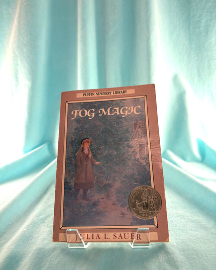 Book titled 'Fog Magic' by Julia L. Sauer on a light blue curtain background