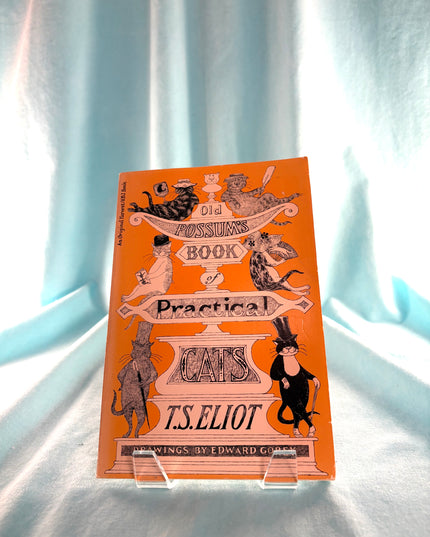 Book cover of 'The Book of Practical Cats' by T.S. Eliot on a light blue curtain background